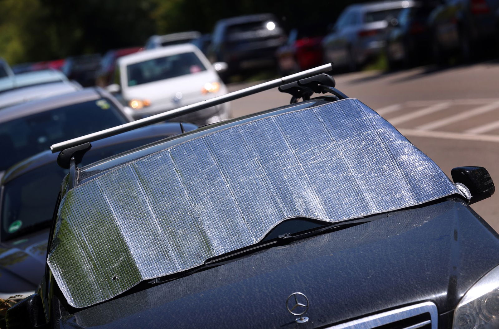 Ein Schutz an der Scheibe kann das Auto beim Parken kühler halten. (Symbolbild)