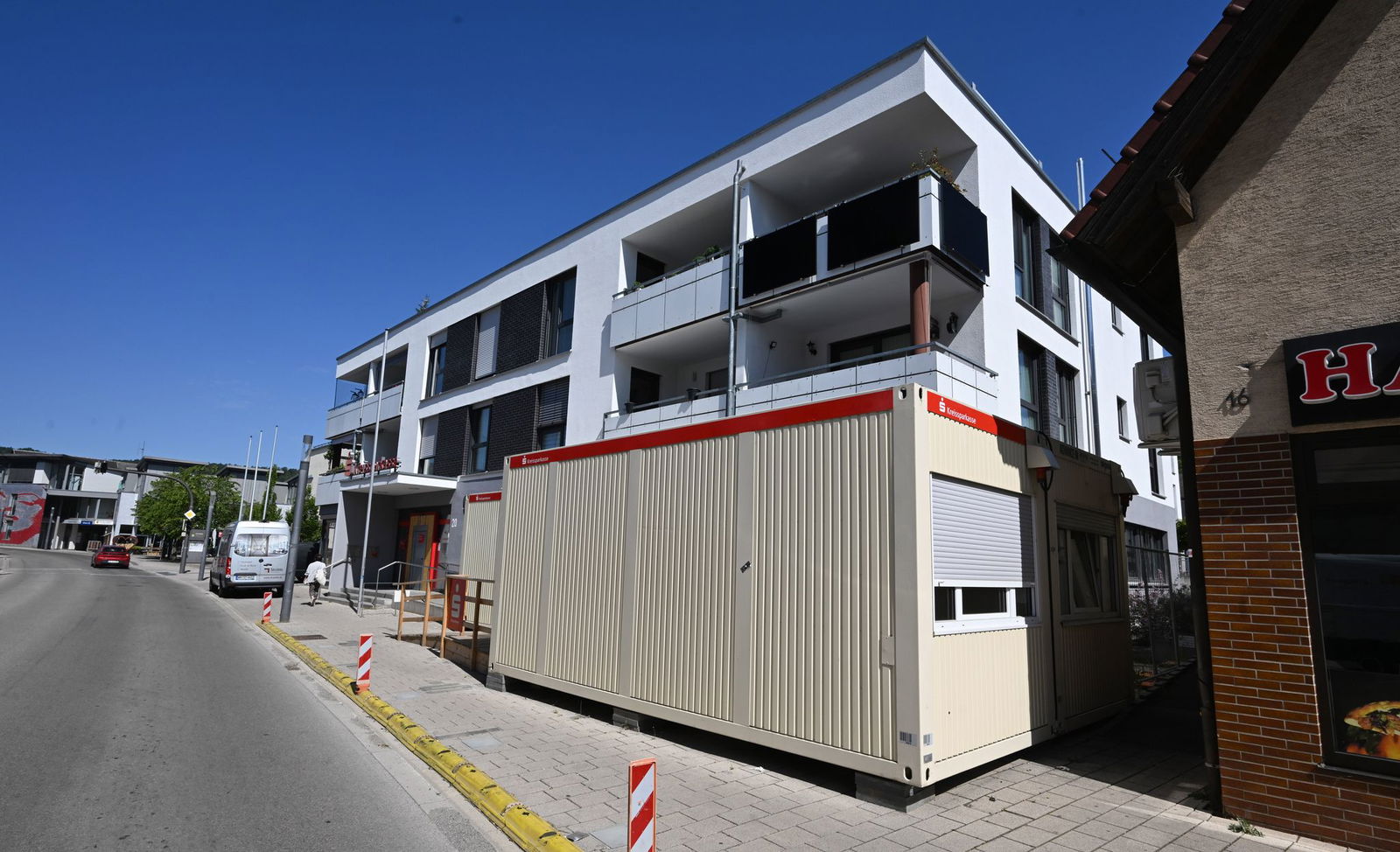 Container der Sparkasse stehen vor einem Gebäude. Die Bankfiliale wurde ein Jahr zuvor bei einem Hochwasser beschädgt.