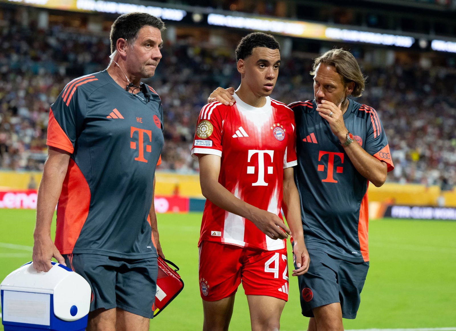 Beim Sieg gegen Boca Juniors musste Jamal Musiala (M), begleitet von Teamarzt und Physiotherapeut, angeschlagen vom Platz.