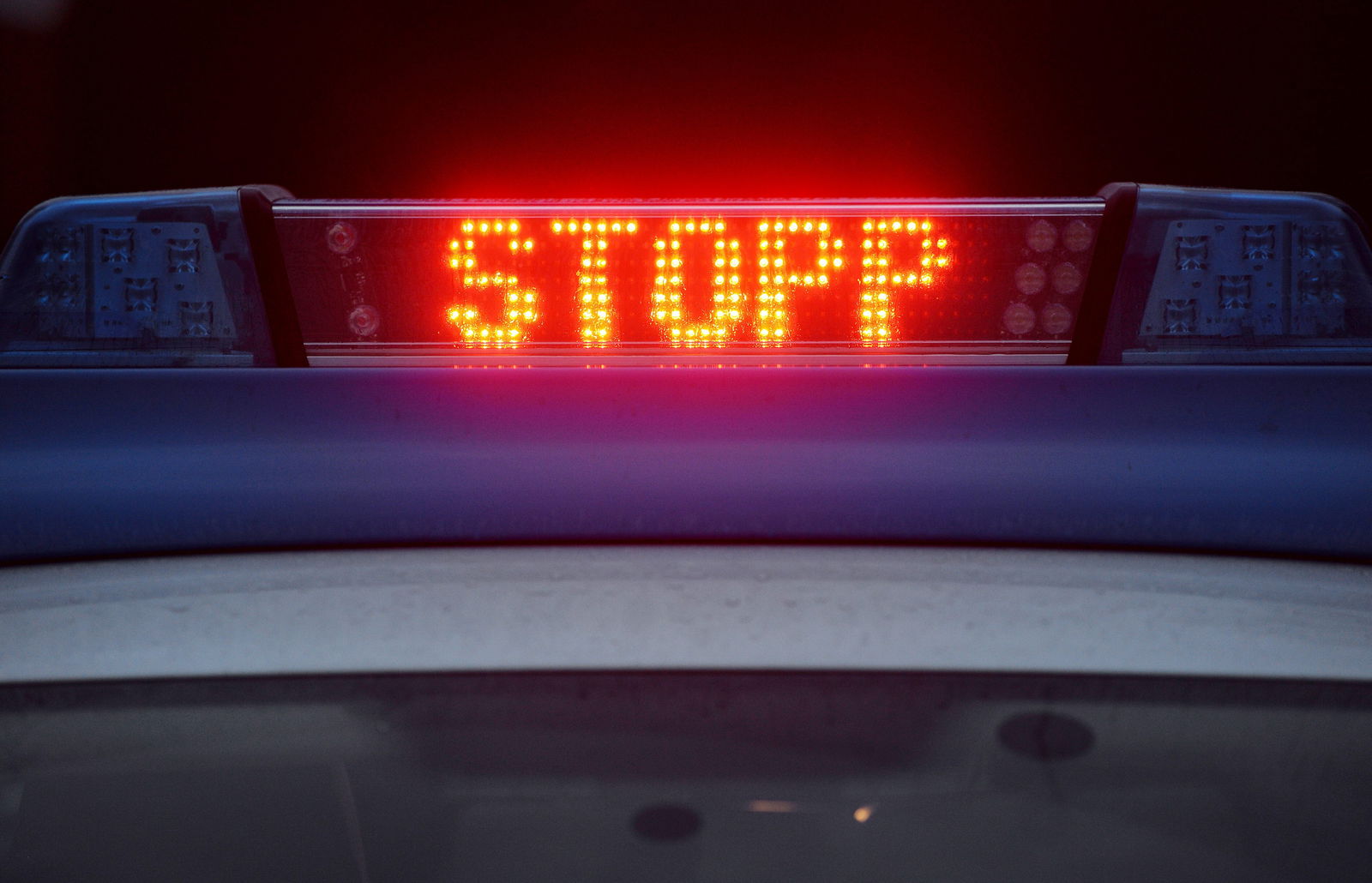 Lichtaufschrift Stopp bei einem Polizeiwagen
