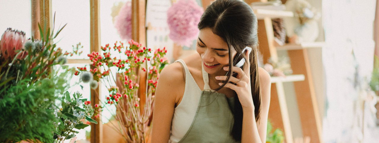 frau am telefon im blumenladen
