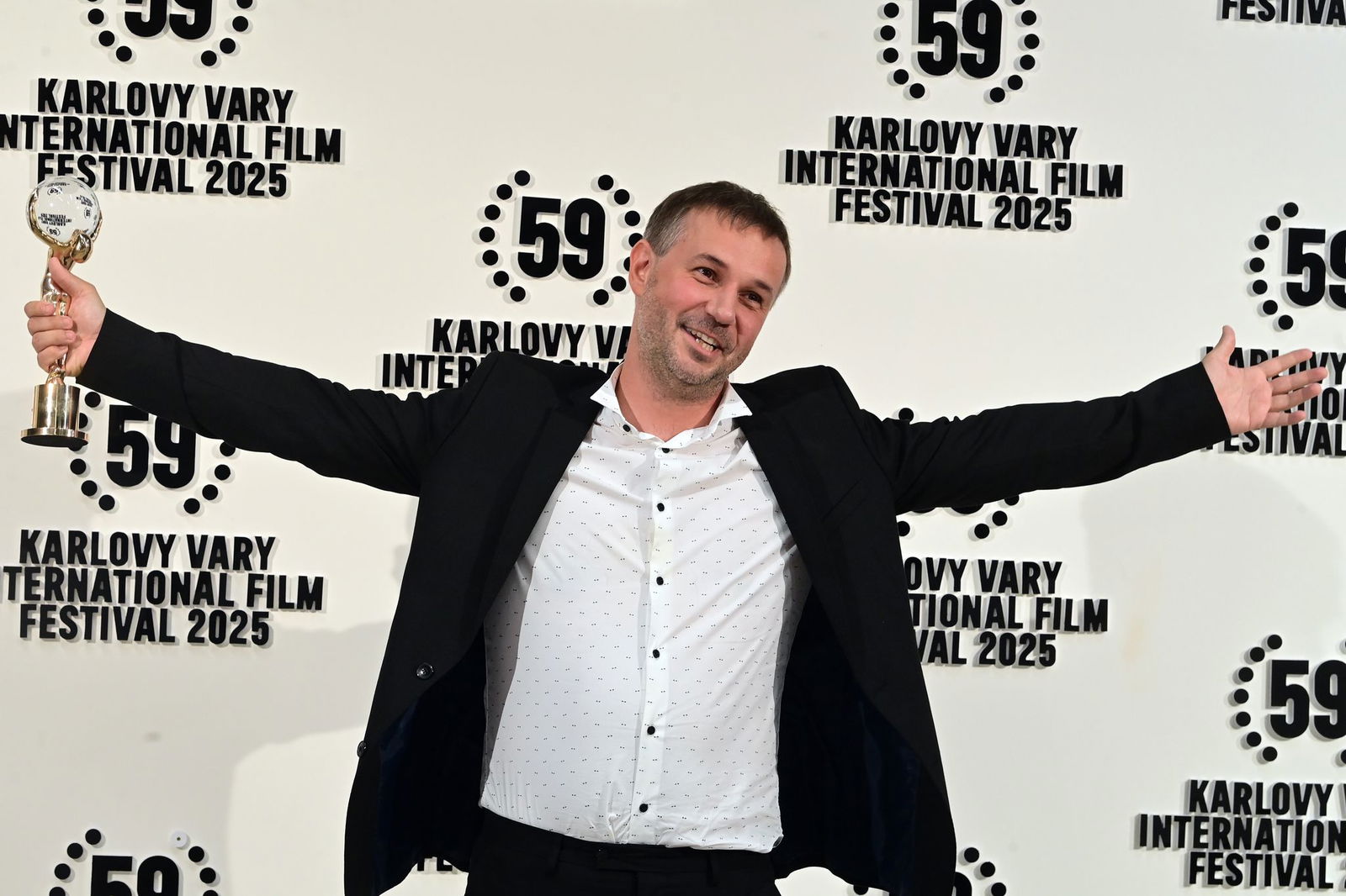 Der slowakische Regisseur Miro Remo posiert mit seiner Auszeichnung in der Hand. Miro gewann den Hauptpreis des 59. Karlsbader Filmfestivals.