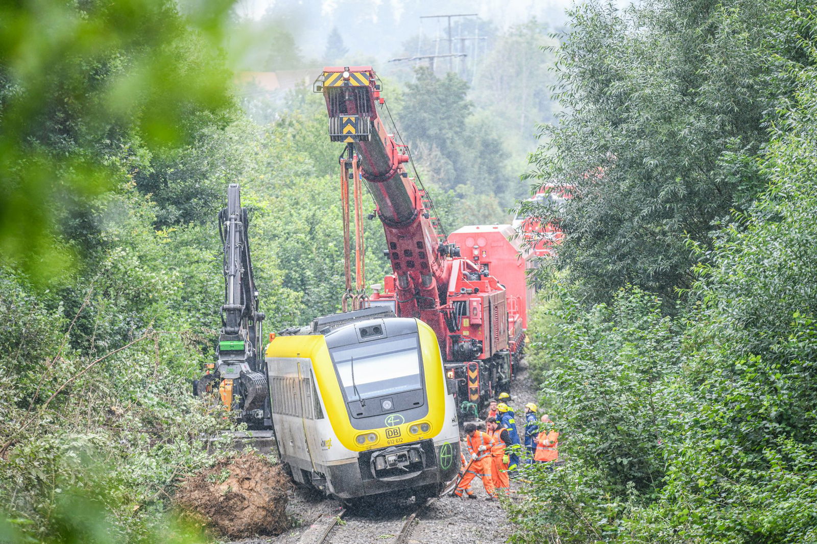 Mit einem Kran wird an der Unfallstelle, an der ein Regionalzug entgleist ist, gearbeitet. Ein Regionalexpress war am Sonntagabend (27.07.2025) in Riedlingen nach bisherigen Erkenntnissen infolge eines Hangrutsches entgleist.