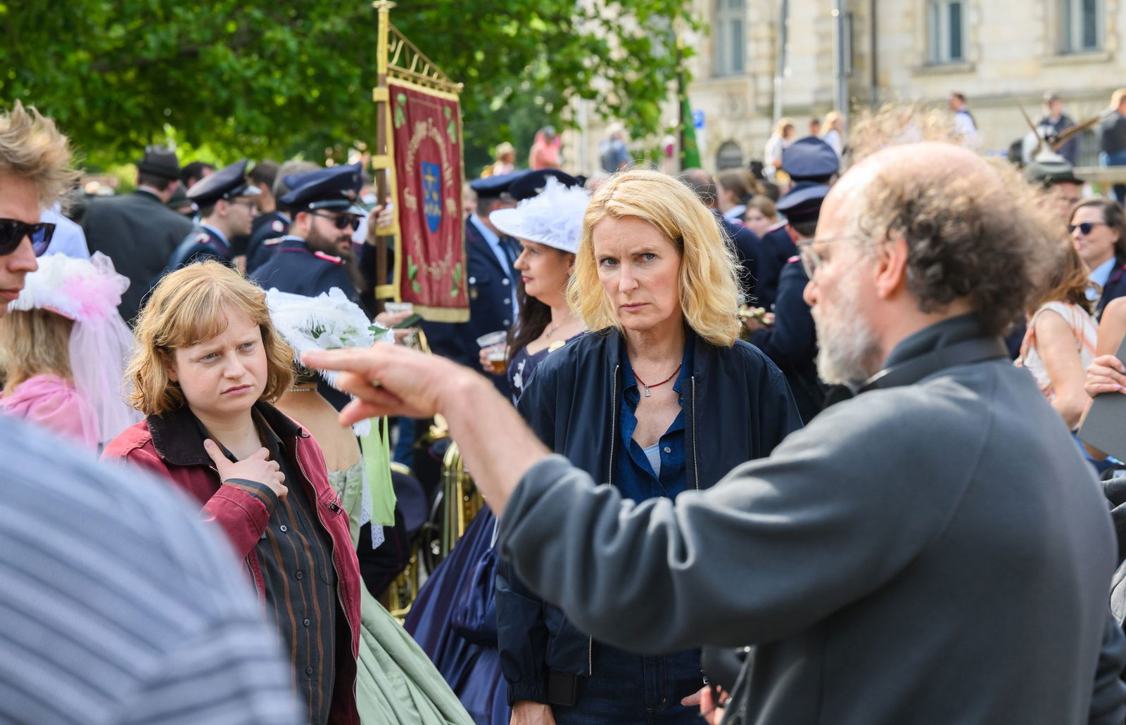 Die Schauspielerinnen Luise von Stein (l) und Maria Furtwängler stehen bei Dreharbeiten für einen neuen fiktiven „Tatort“ inmitten des realen Schützenausmarsches am Neuen Rathaus.