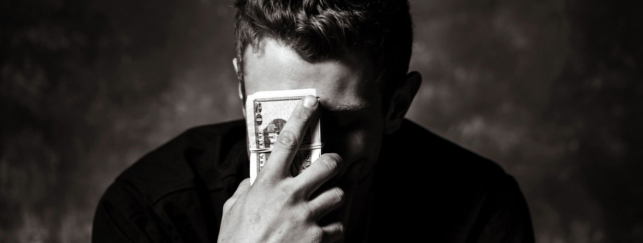 Mann mit Geld vor dem Gesicht