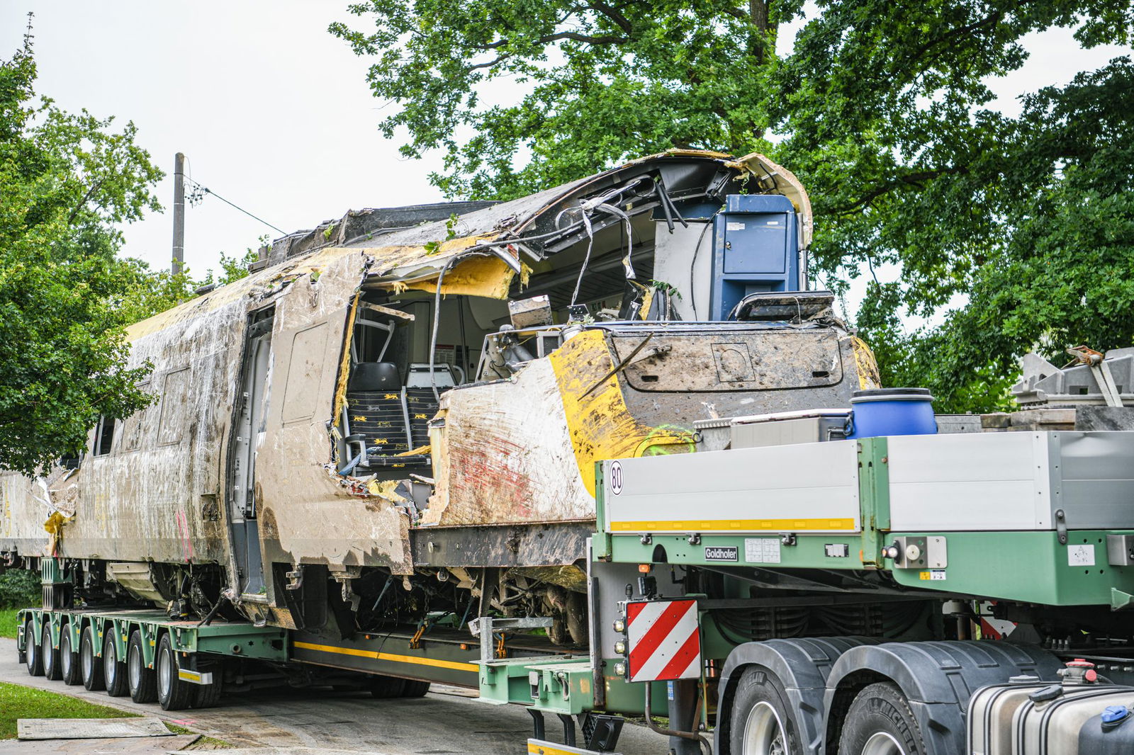 Ein Waggon ist zum Abtransport auf einen Tieflader verladen worden.