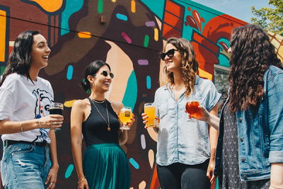 Frauen lachen mit Getränk