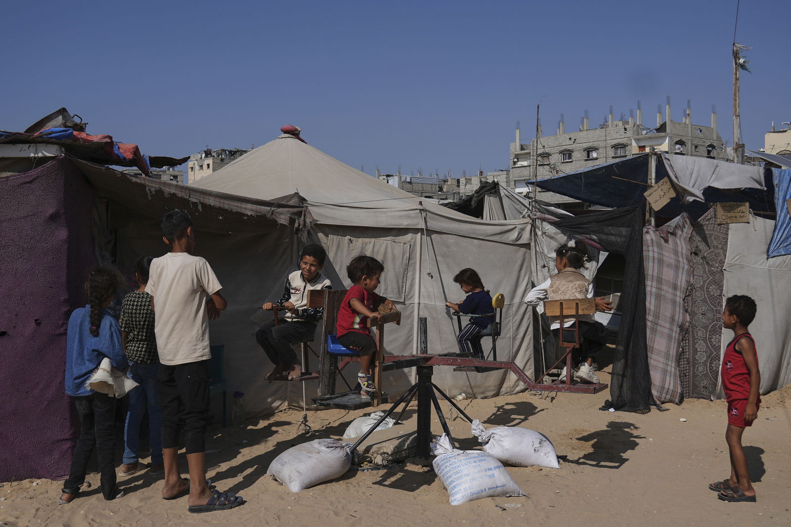 Vertriebene palästinensische Kinder spielen am Freitag, den 6. Juni 2025, am ersten Tag des Eid al-Adha in einem Zeltlager in Khan Younis, Gaza.