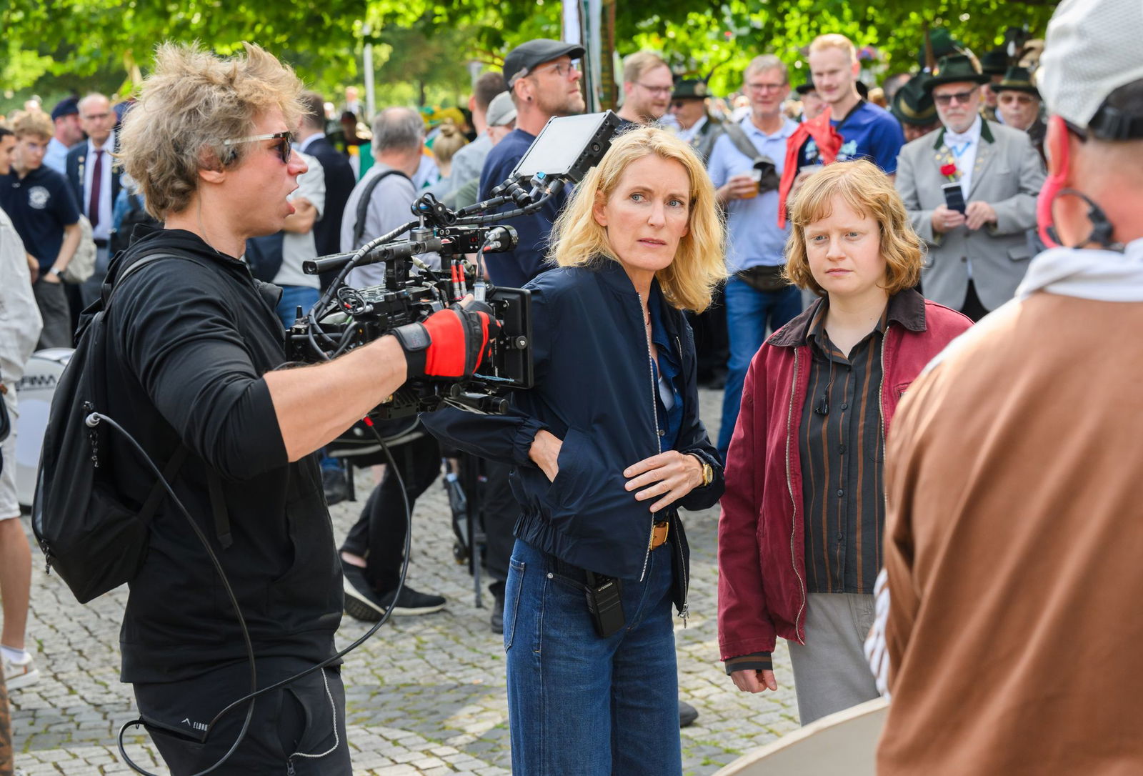 Die Schauspielerinnen Maria Furtwängler (l) und Luise von Stein spielen eine Szene bei Dreharbeiten für einen neuen fiktiven „Tatort“ inmitten des realen Schützenausmarsches am Neuen Rathaus. 