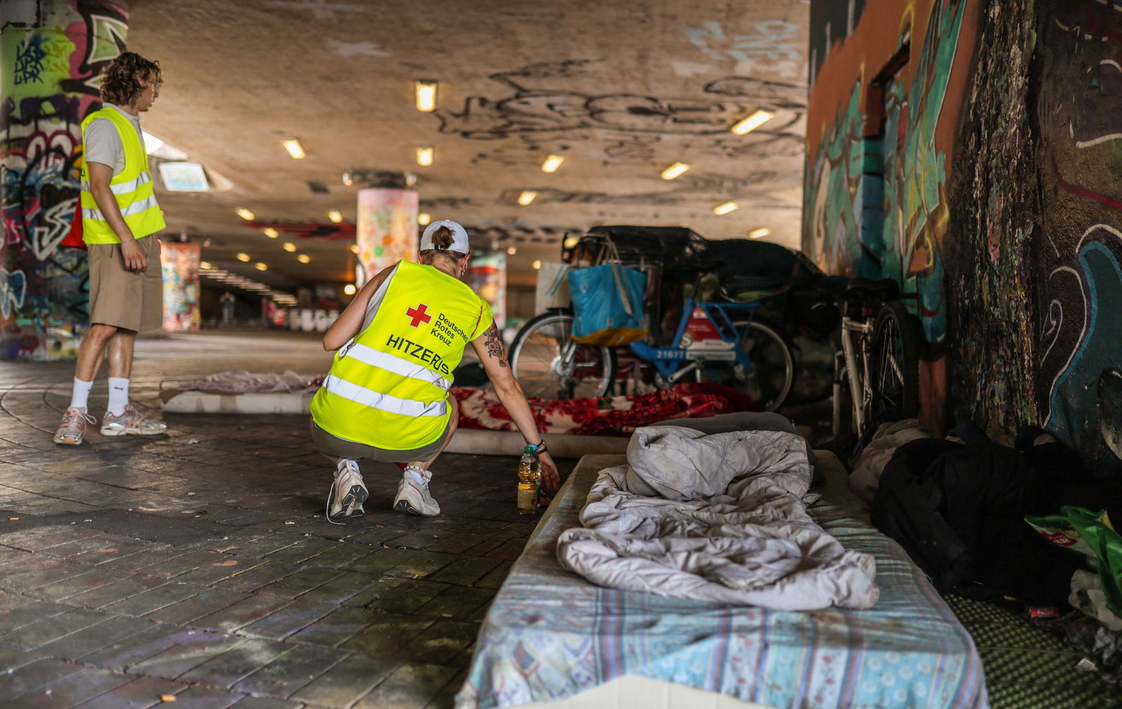 Unter eine Brücke steuern die beiden Helfer auf ein Lager von Obdachlosen zu.
