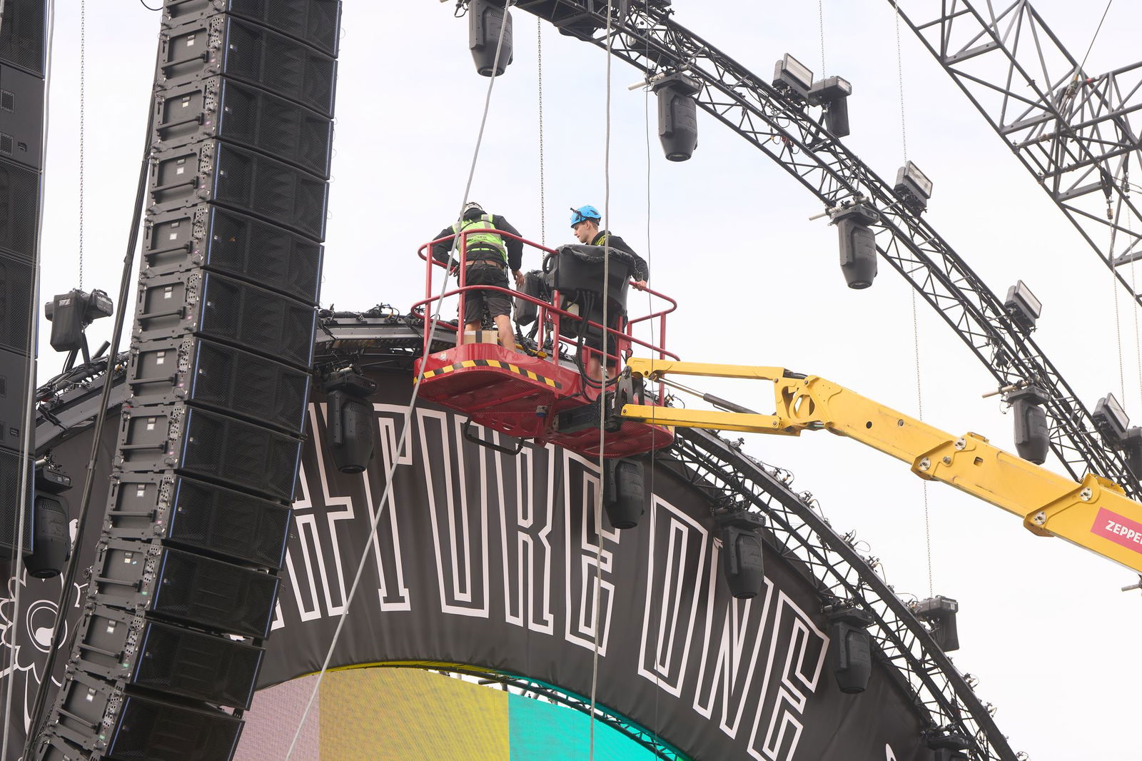 Techniker bauen eine Bühne des Technofestivals. Bereits am Donnerstag reisten Zehntausende an. 