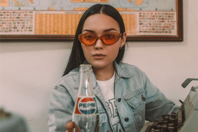 frau mit sonnenbrille und pepsi