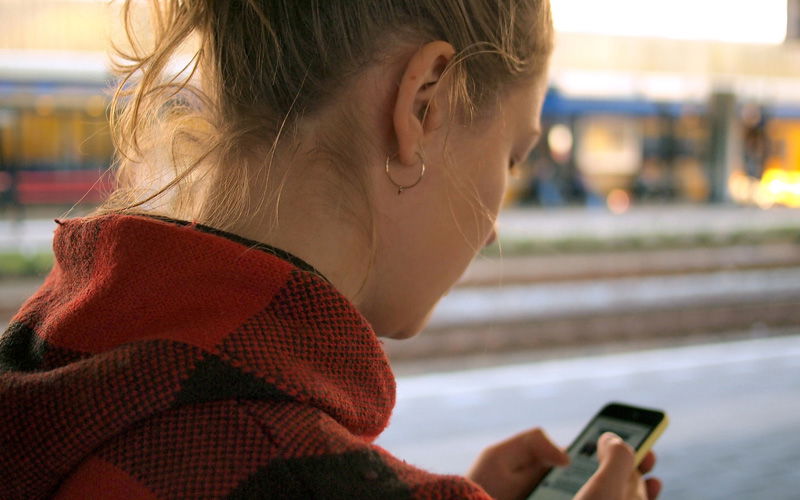 Mädchen von hinten am Handy