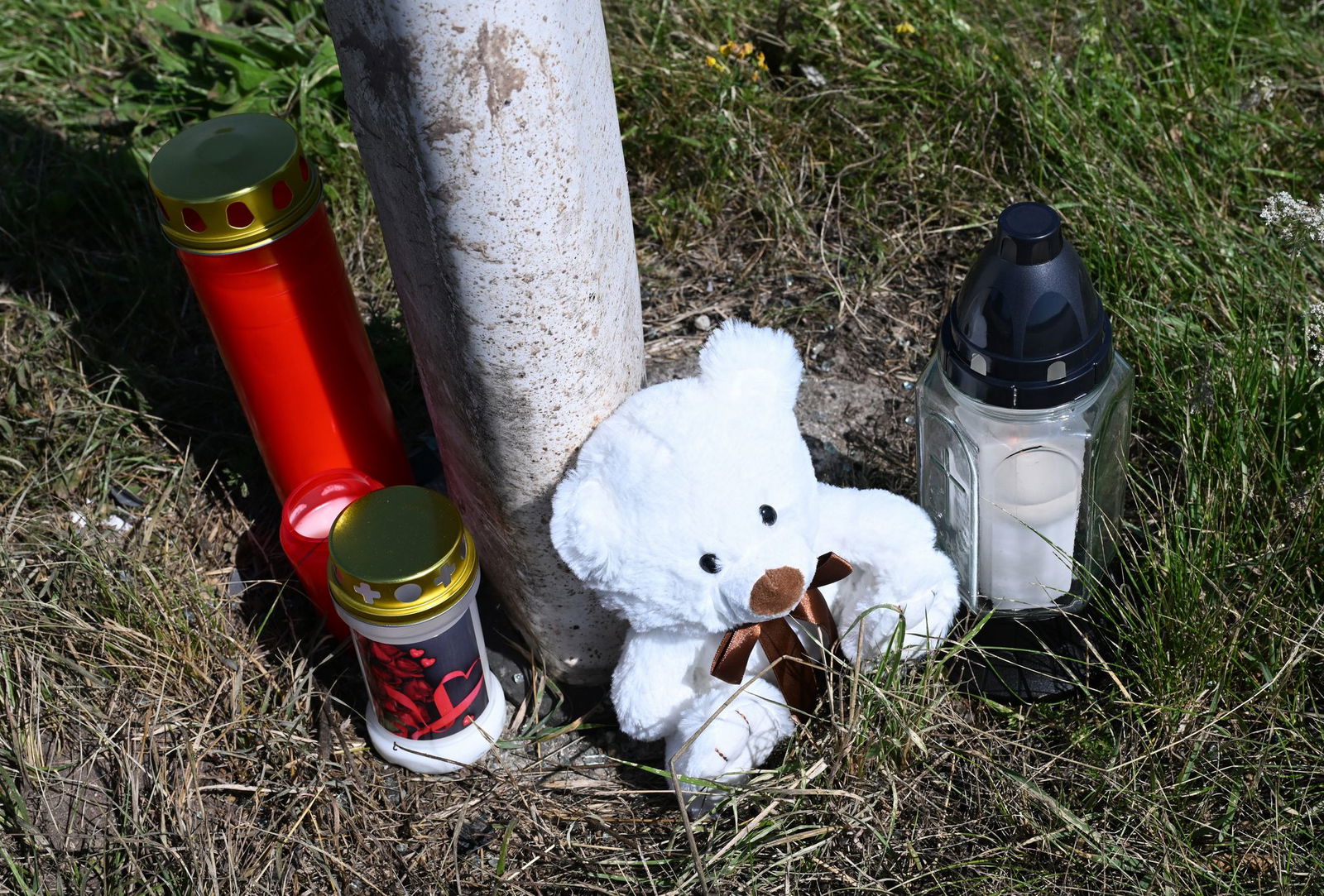 Menschen haben Kerzen und einen Teddybären an der Unfallstelle abgestellt.