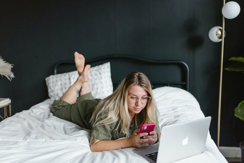 frau mit laptop auf bett
