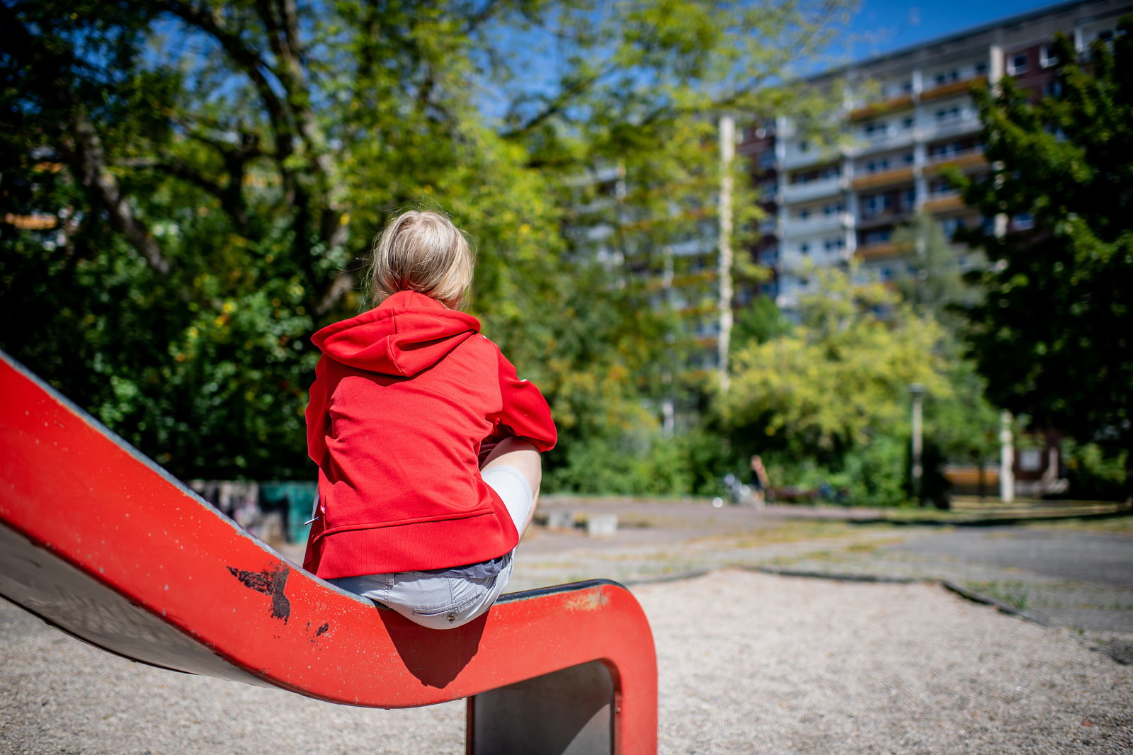 Ein Kind sitzt auf einer Rutsche auf einem Spielplatz