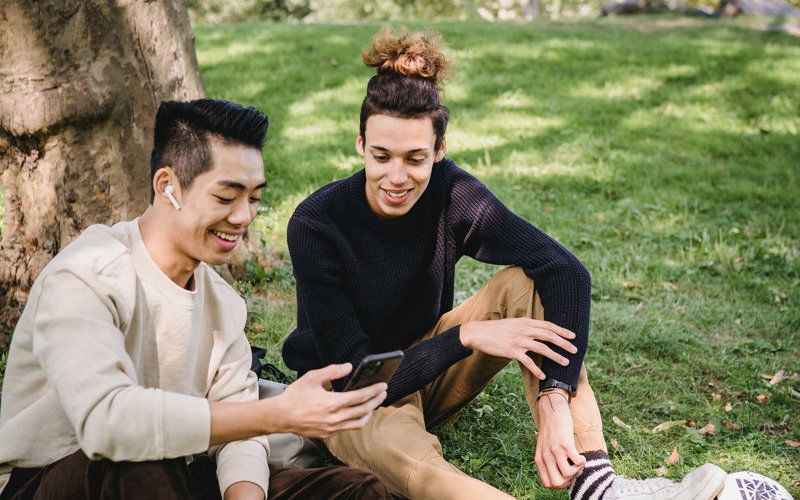Studenten sitzen zusammen im Gras