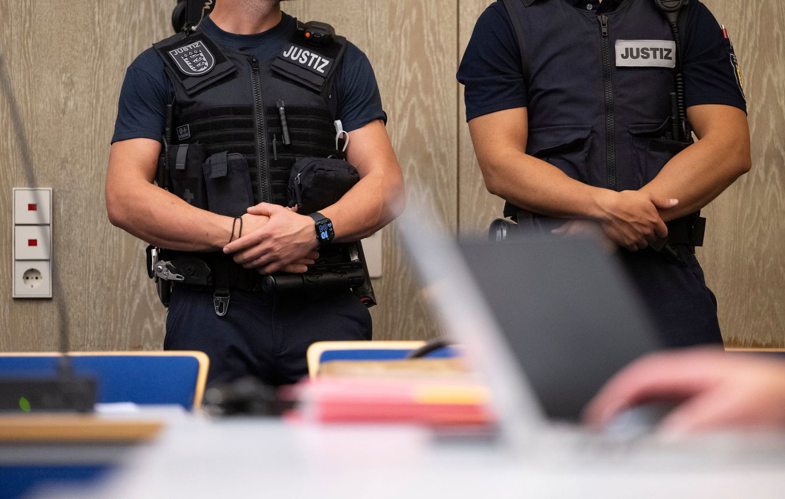 Justizbeamte stehen beim Auftakt im Prozess gegen drei junge, mutmaßliche IS-Sympathisanten in einem Saal des Landgerichts Mannheim. 