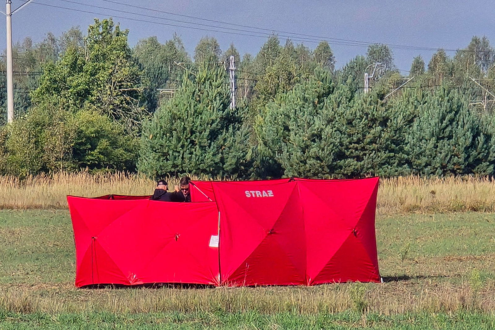 Feuerwehrleute sichern Teile einer abgeschossenen Drohne auf einem Gelände in Czosnowka bei Biala Podlaska.