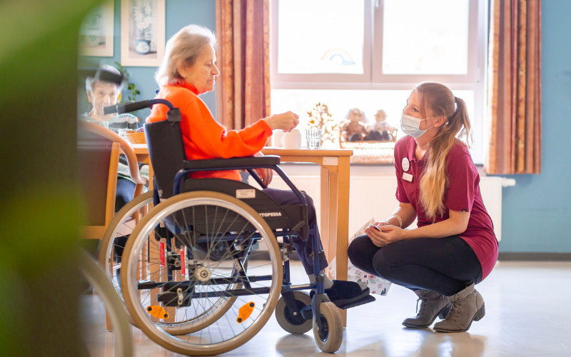 Altenpflegerin betreut Frau im Rollstuhl