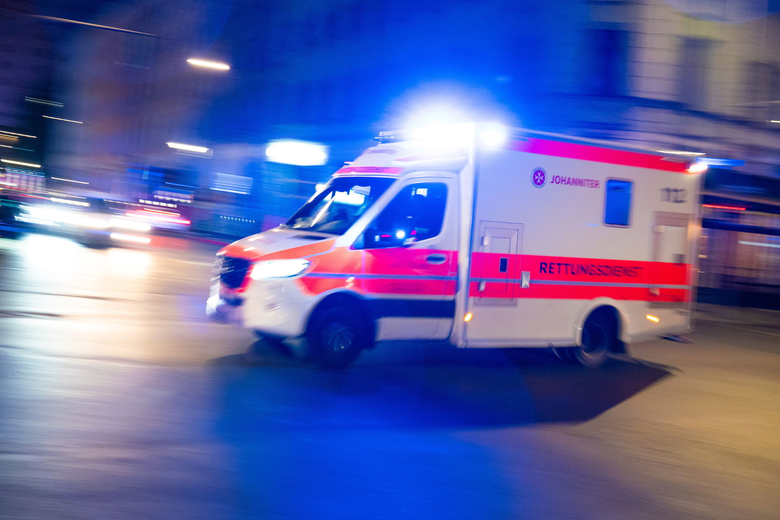 Rettungswagen fährt mit Blaulicht durch die Straße