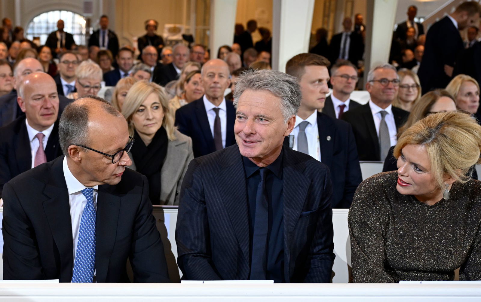 Zum ersten Mal gemeinsam beim Einheitsfest: Bundestagspräsidentin Julia Klöckner (CDU) mit ihrem Lebensgefährten Jörg Pilawa (M.) - im Gespräch mit Bundeskanzler Friedrich Merz (CDU) in der Ludwigskirche.