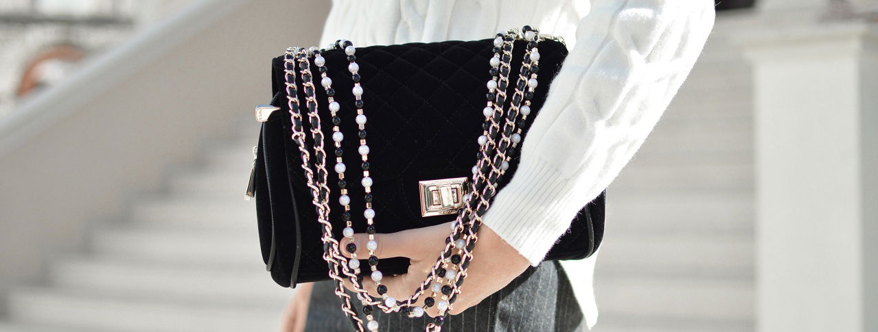 Frau hält schicke schwarze Tasche in der Hand