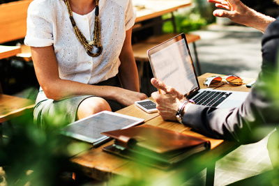 personen sitzen im gespräch am tisch mit einem laptop