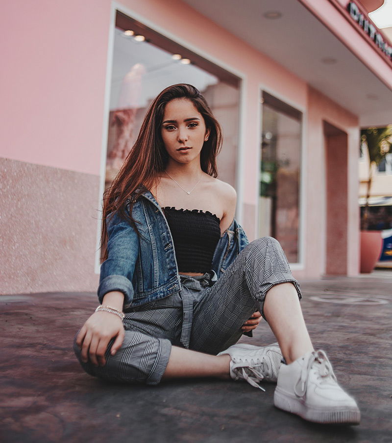 Frau vor pinkem Gebäude schaut in die Kamera