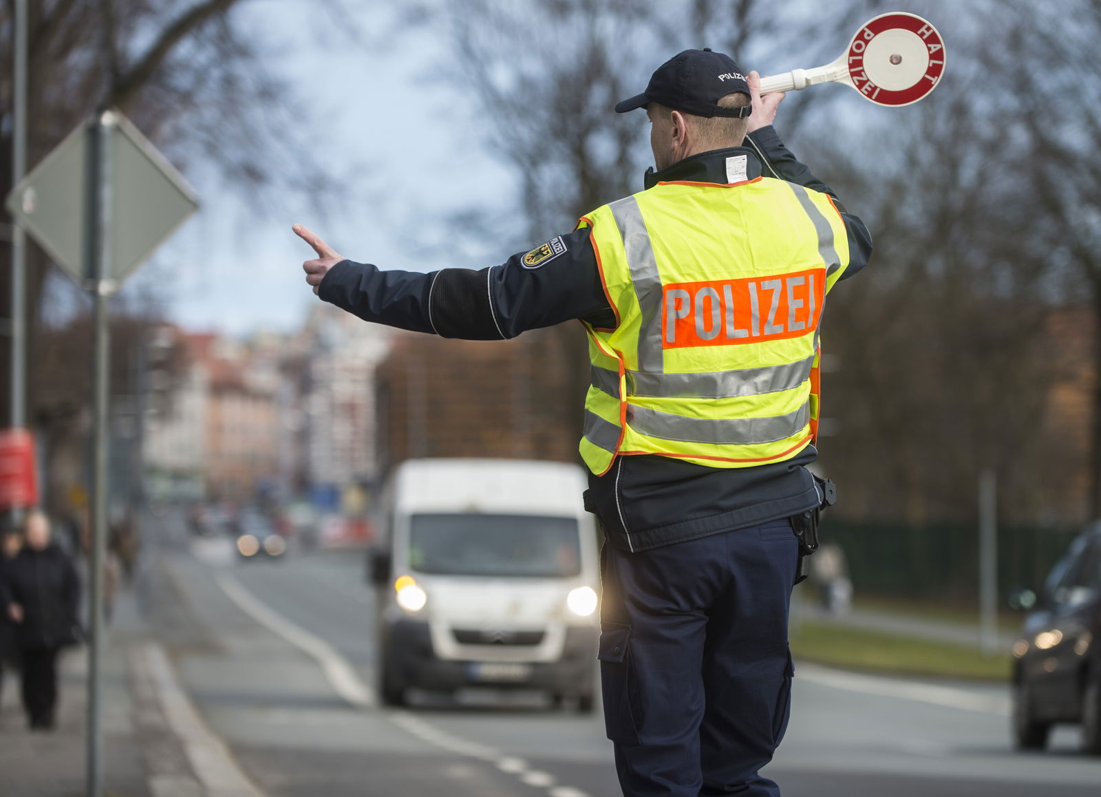 Polizist winkt einen Transporter zur Kontrolle 