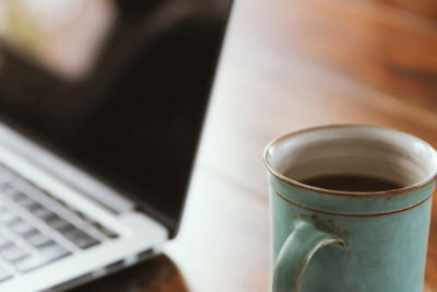 kaffe in der tasse neben laptop