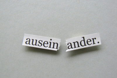 Zerrissenes Stück Papier mit Aufschrift "auseinander" 