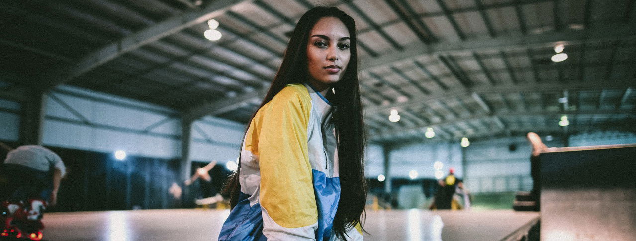 Frau stehtin einer Halle und schaut in die Kamera