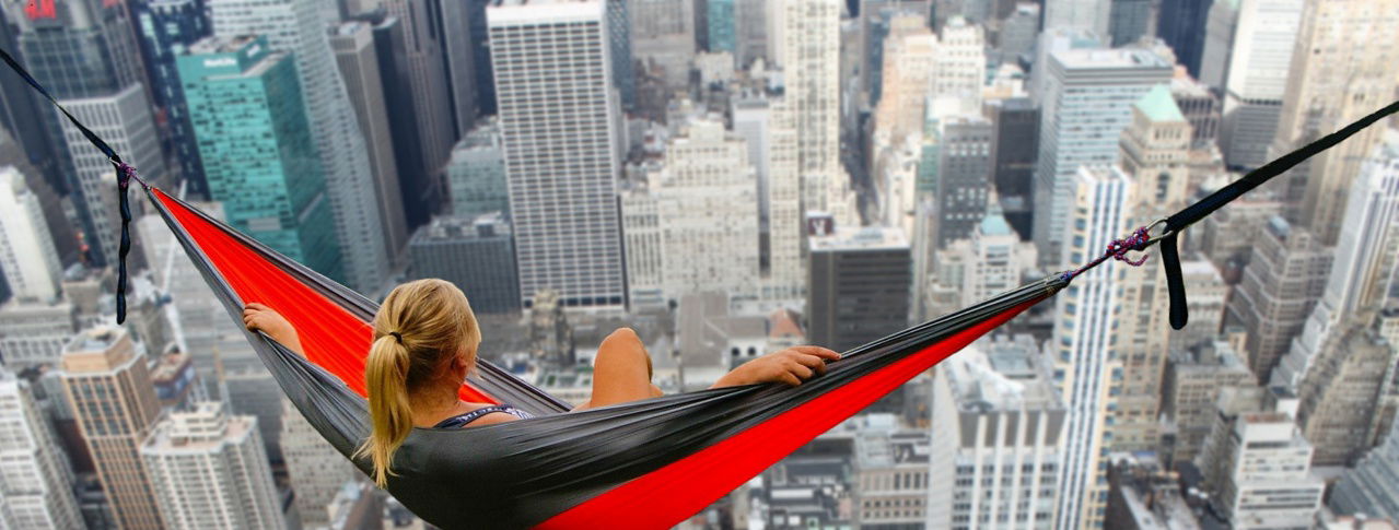 frau schaut mit hängematte auf skyline