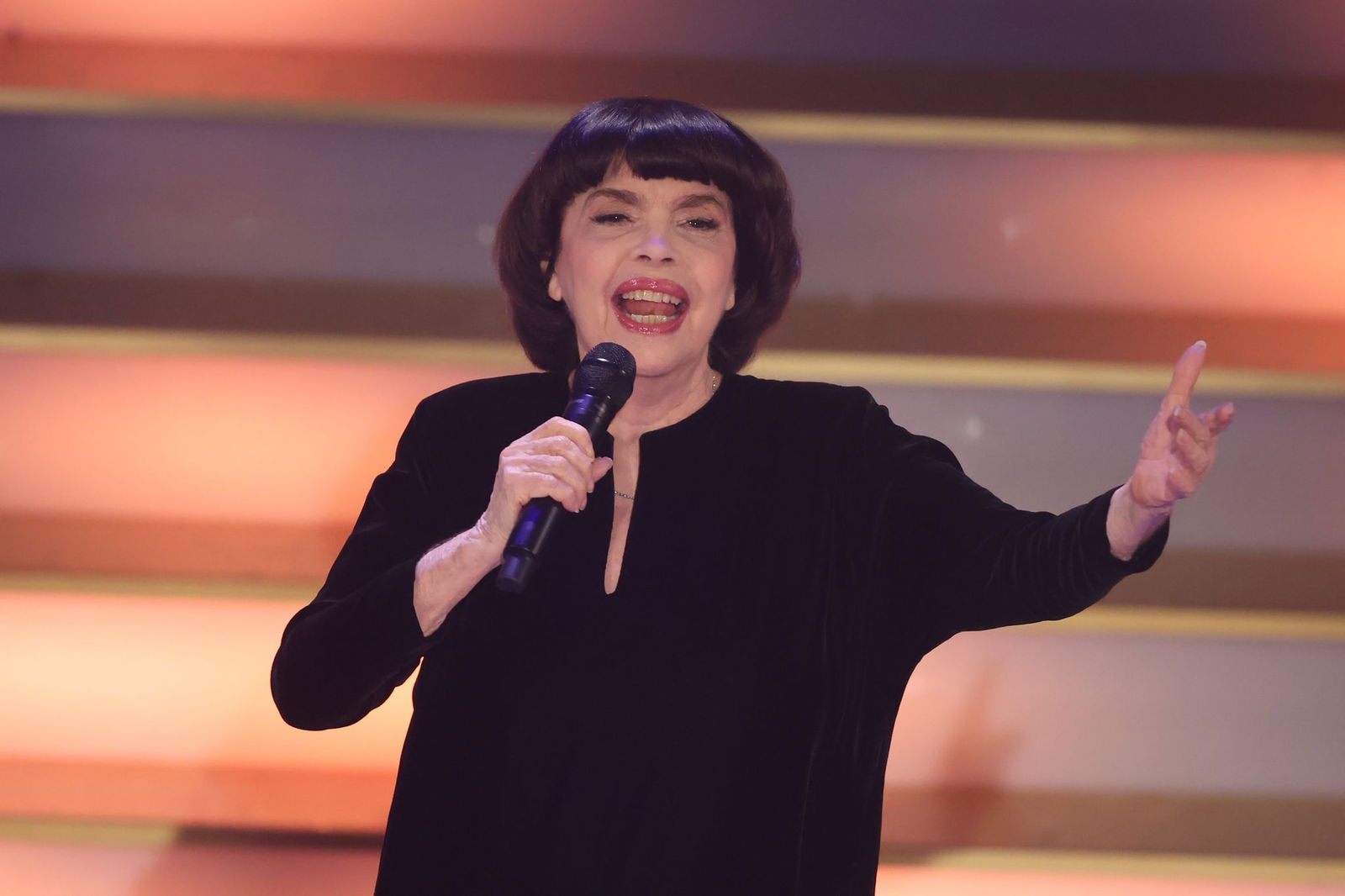 Mit Chanel-Hut und chinesischem Sonnenschirm schützt Chanson-Legende Mireille Mathieu ihre Haut. (Archivbild)