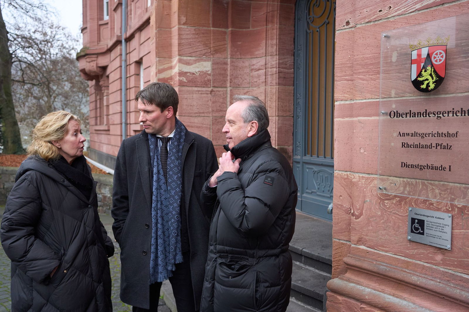 Anwalt Hecken (Mitte) steht mit den Eltern eines Flutopfers vor dem Koblenzer Oberlandesgericht. 