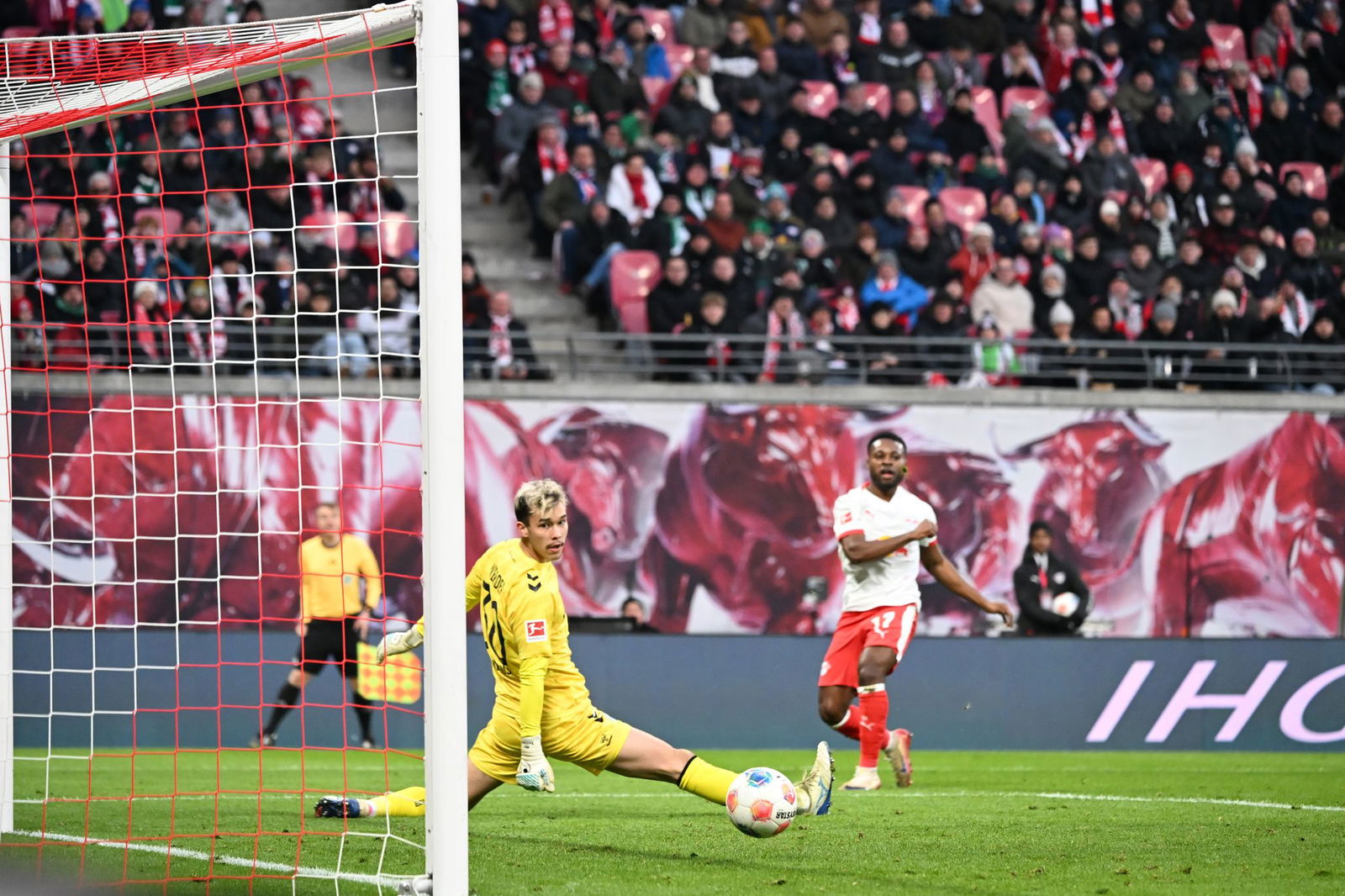 Bremens Torwart Mio Backhaus (l, Werder Bremen) und Ridle Baku (RB Leipzig) schauen dem Ball hinterher. Backhaus verhinderte mit seinen Paraden einen frühen Rückstand der Gäste in Leipzig.
