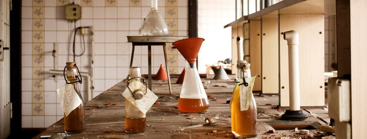 Flaschen und Reagenzgläser stehen auf Tisch 