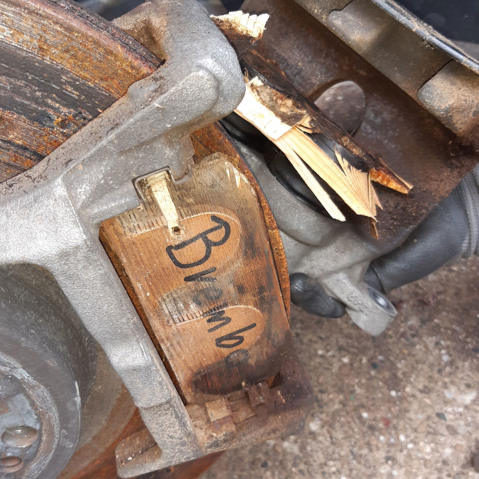 Auf dem Holzklotz steht mit der Filzstift der Name eines Autozulieferers geschrieben