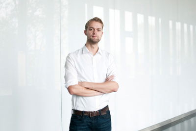 Mann steht schick da mit Händen überkreuzt