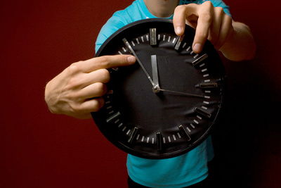 Mann zeigt mit Finger auf Uhrzeiger