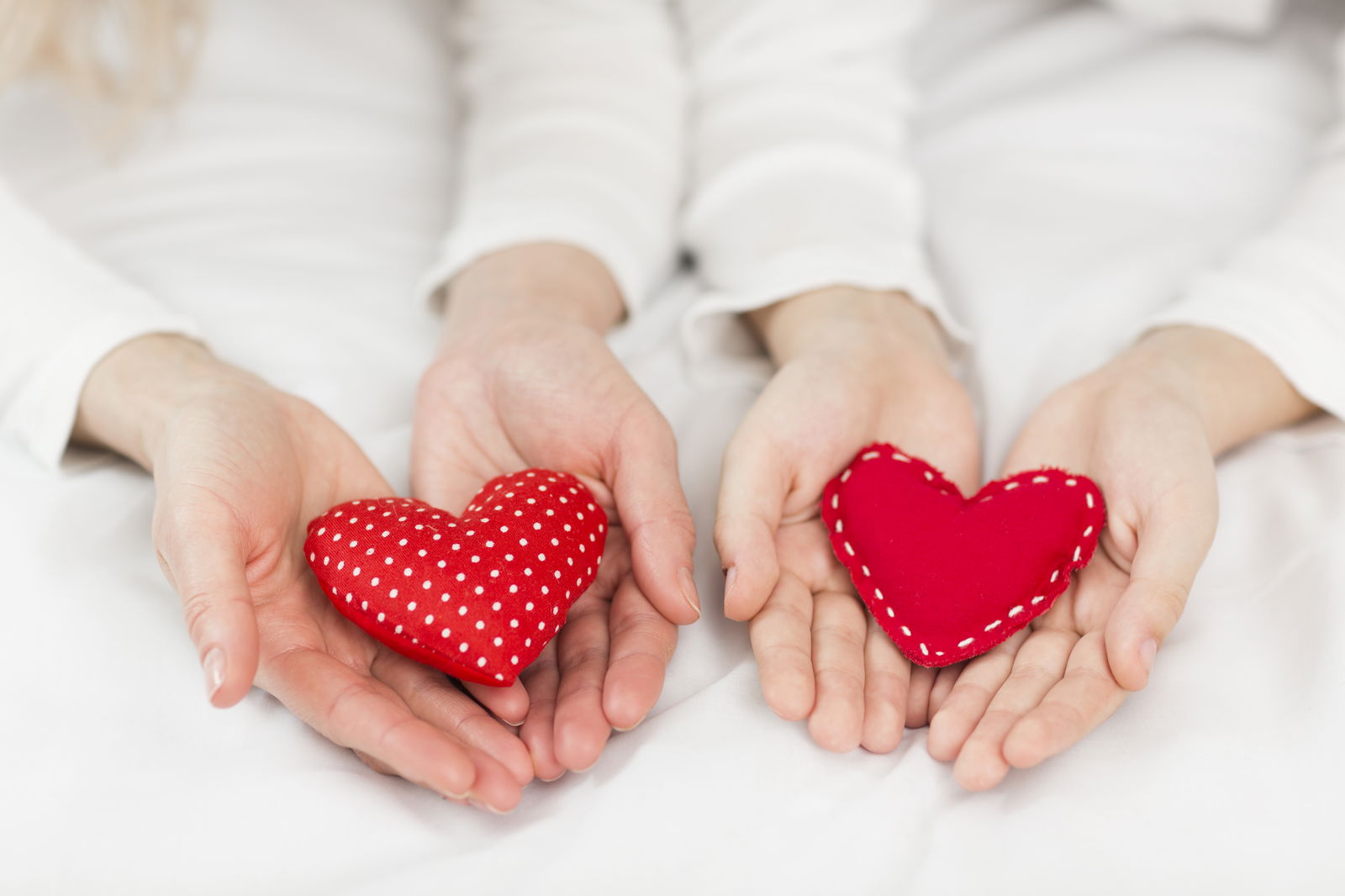 Hände halten rote Herzen