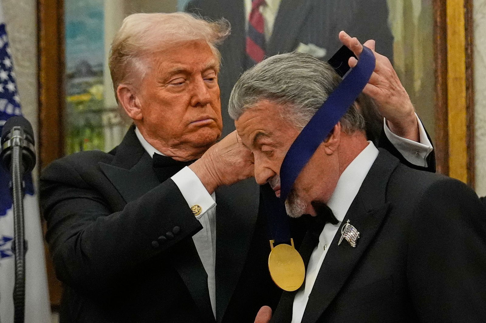 US-Präsident Donald Trump hängt der Actionfilm-Ikone Sylvester Stallone eine Medaille um. 