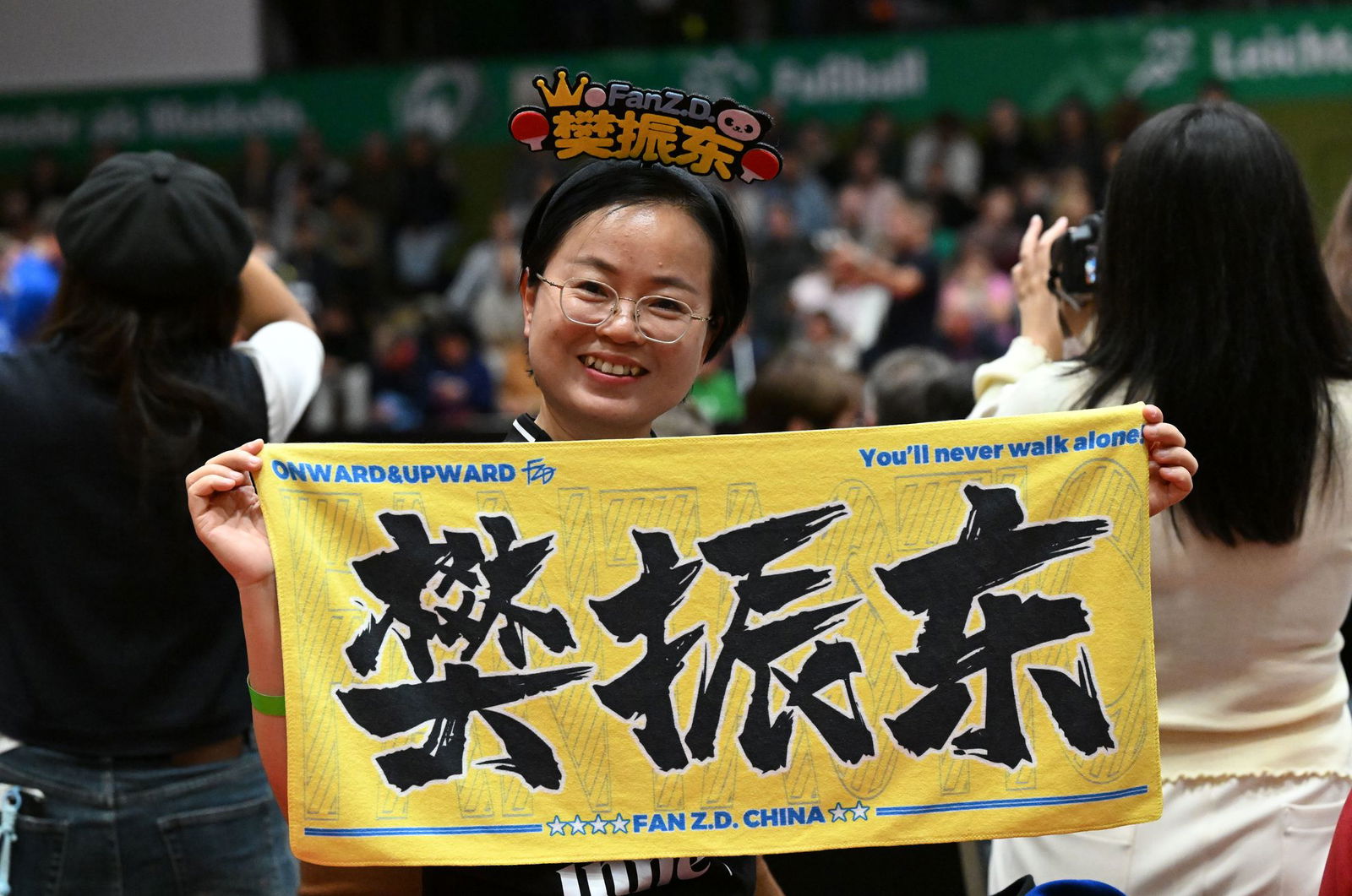 Eine chinesische Anhängerin hält beim Bundesliga-Spiel zwischen Werder Bremen und dem 1. FC Saarbrücken ein chinesisches Fanplakat hoch.