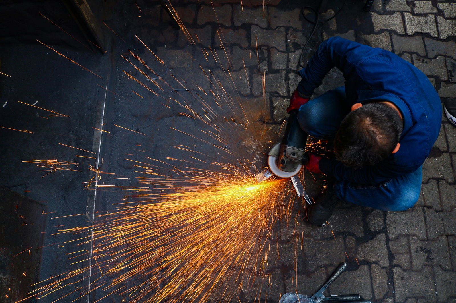 Mann mit Flex und Funken sprühen