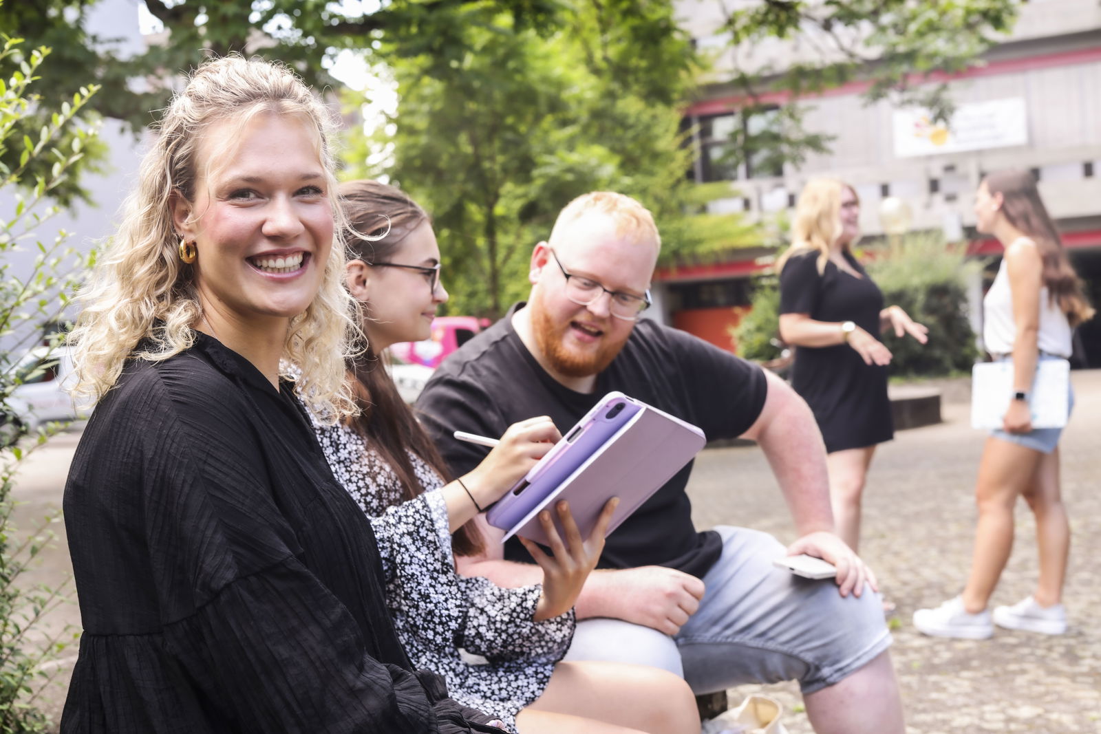 PH Karlsruhe_Studenten sitzen im Hof und unterhalten sich