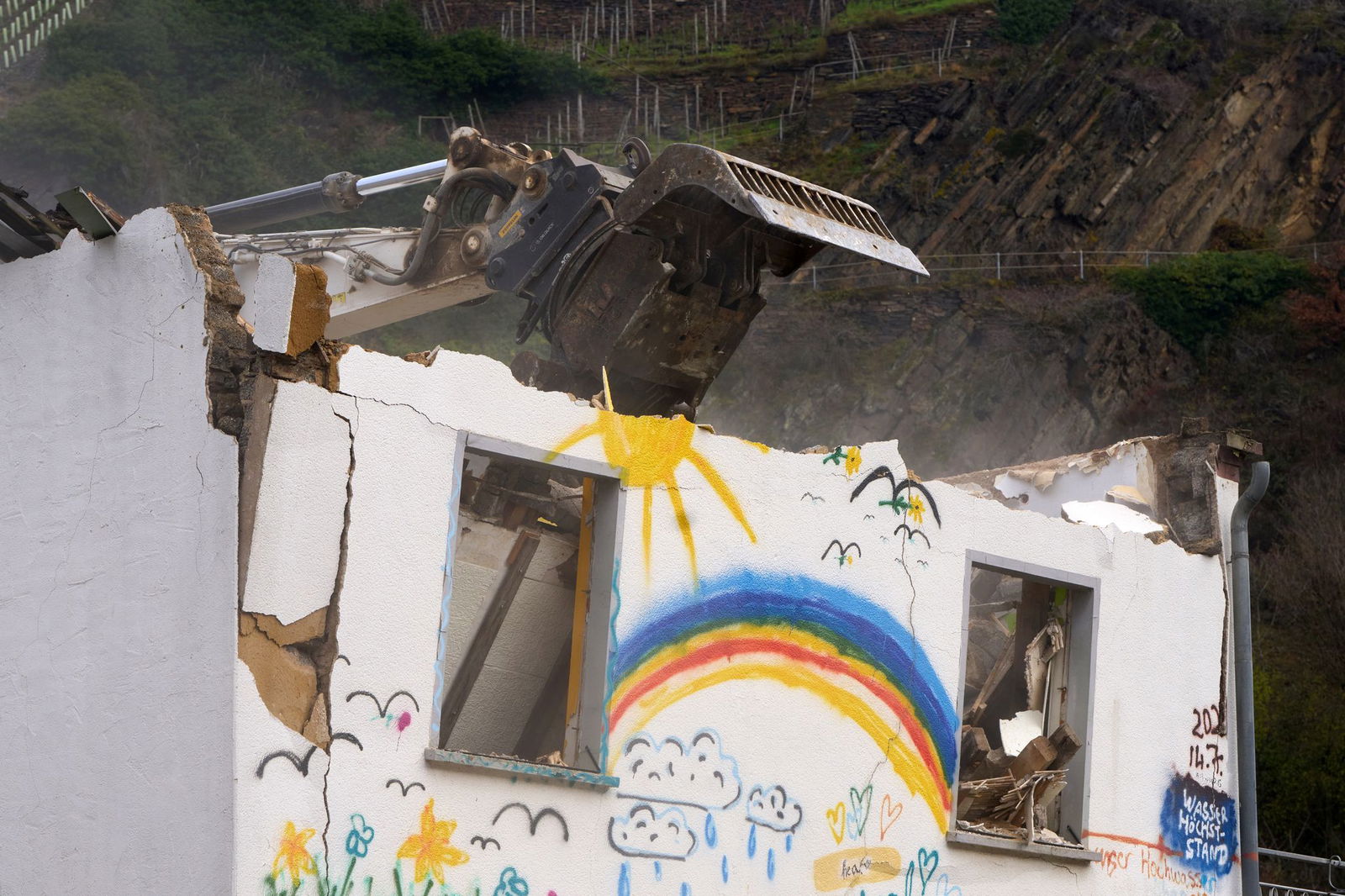 Ein Bagger reißt das Mauerwerk ein.