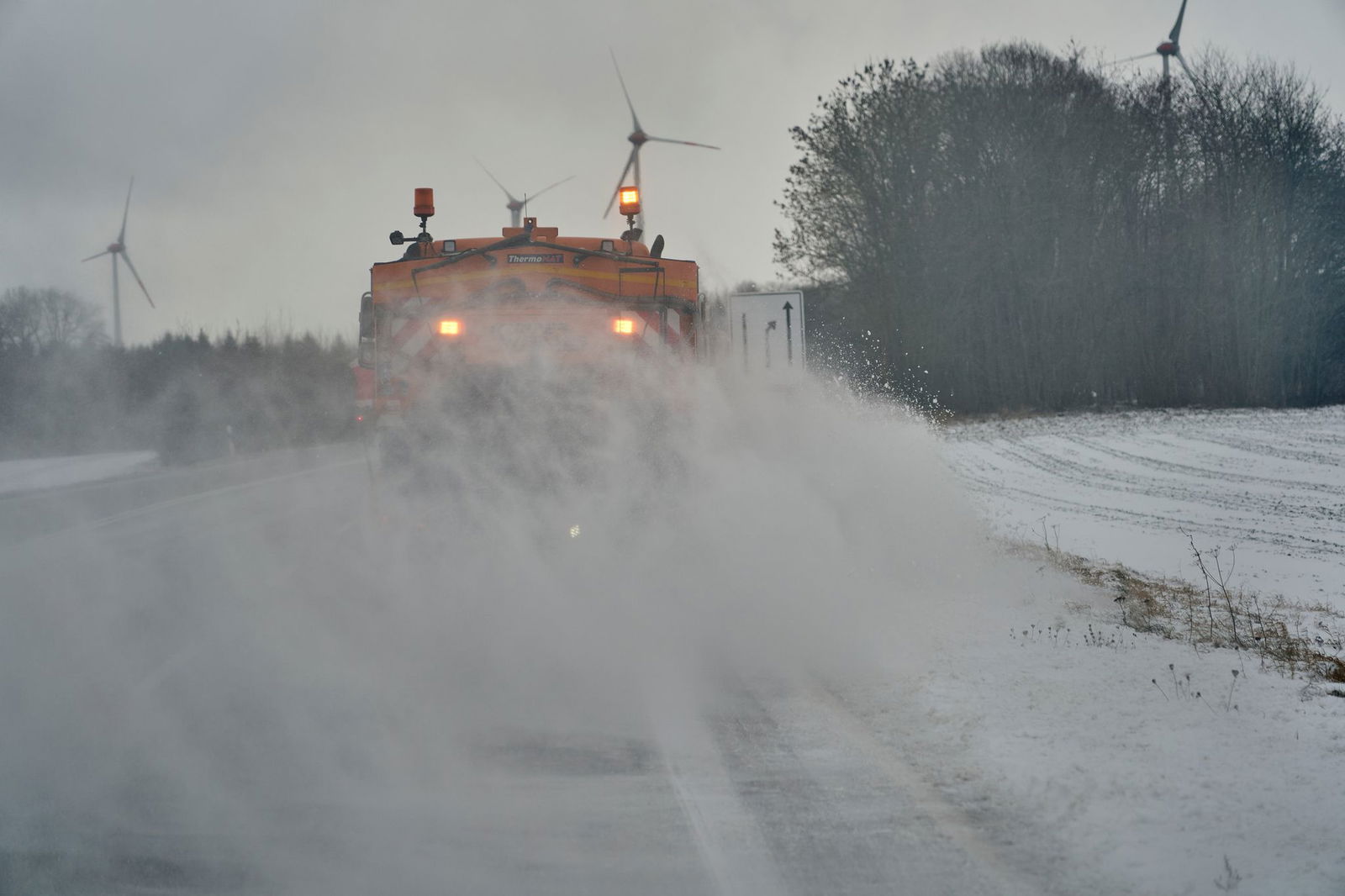 Zwei Fahrzeuge der Straßenmeisterei sind auf der B327 unterwegs, um Schnee und Schneeverwehungen von der Fahrbahn zu beseitigen.