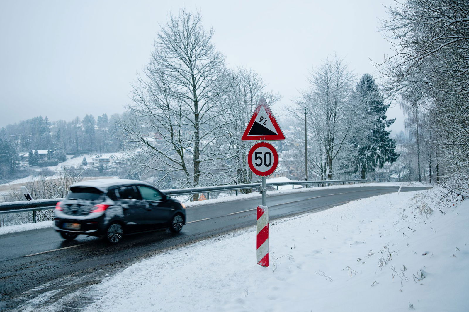 So sieht Winterwetter aus: Ein Auto fährt in einer schneebedeckten Landschaft über eine Straße bei Wilhelmsfeld.
