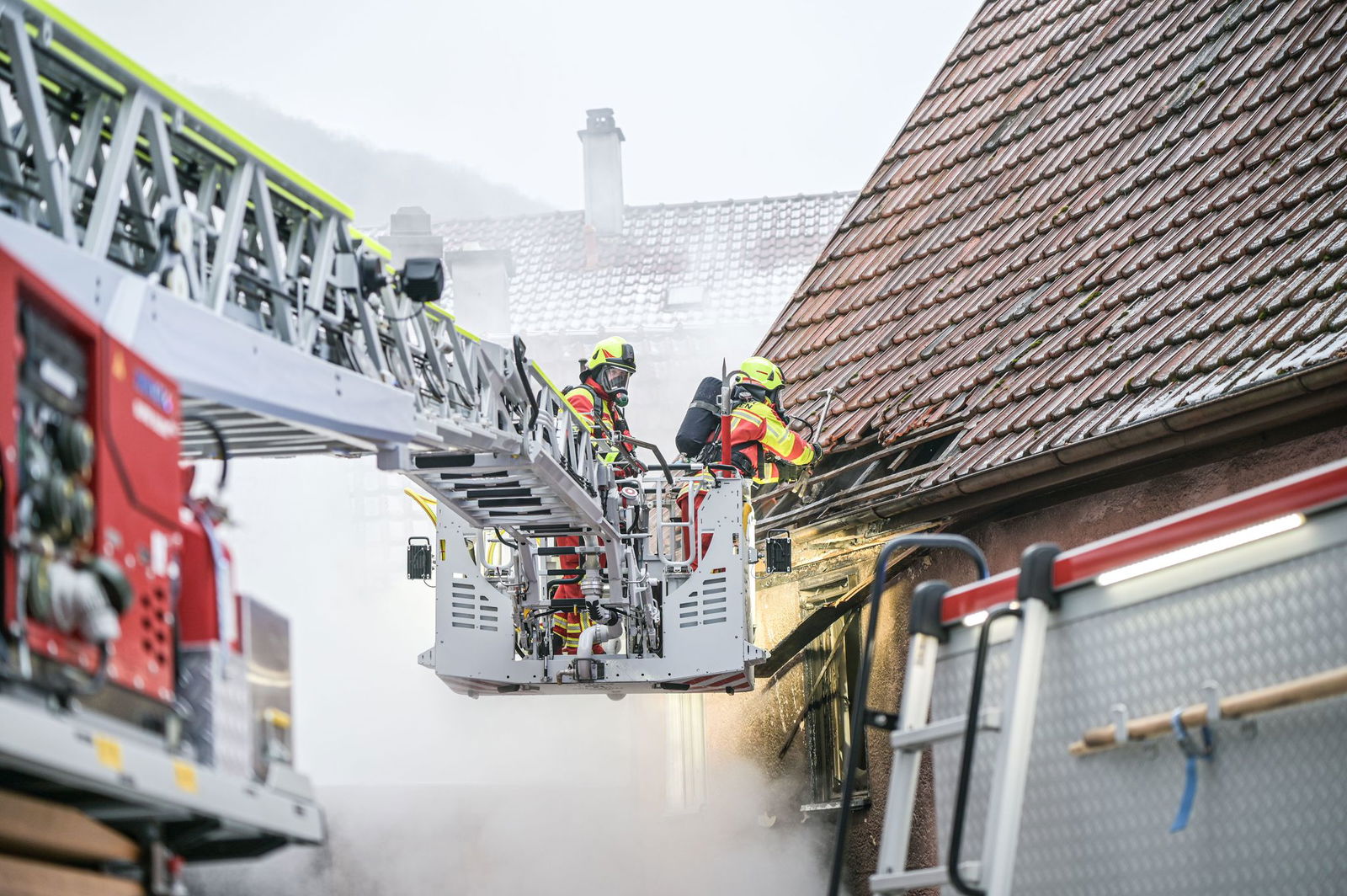 Feuerwehrkräfte bekämpfen den Brand in einem Mehrfamilienhaus. Mehrere Personen wurden verletzt.